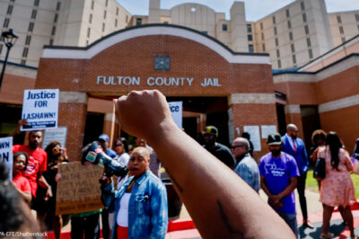 Protester with raised fist in the air at Fulton County Jail after the death of Lashawn Thompson.